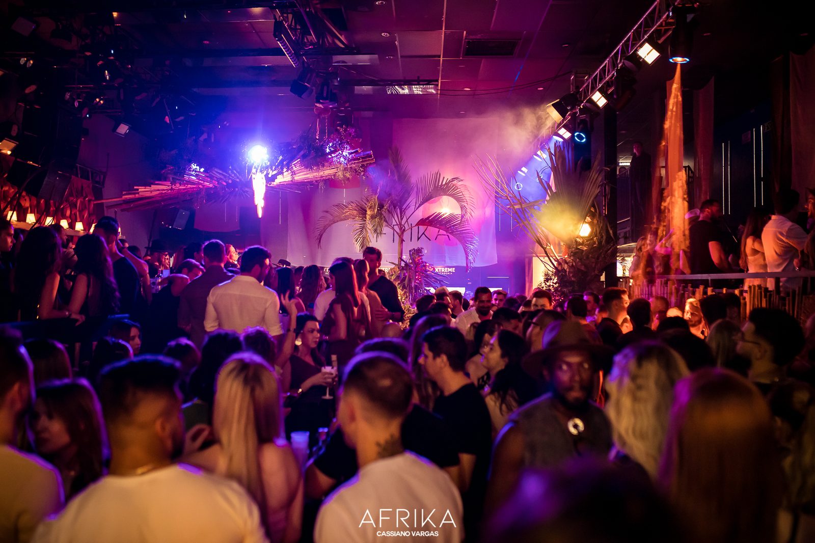 Pista lotada em luz roxa e fumaça durante a festa AFRIKA, em Chapecó